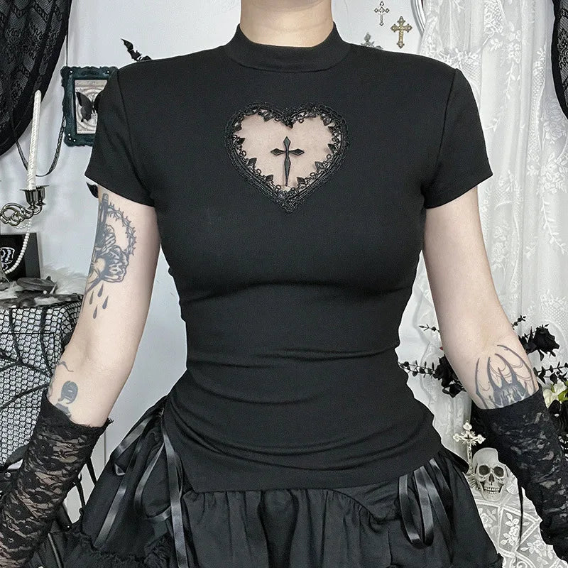 Close front view of the heart-shaped opening in a black T-shirt, bordered with black lace and centred on a cross detail.