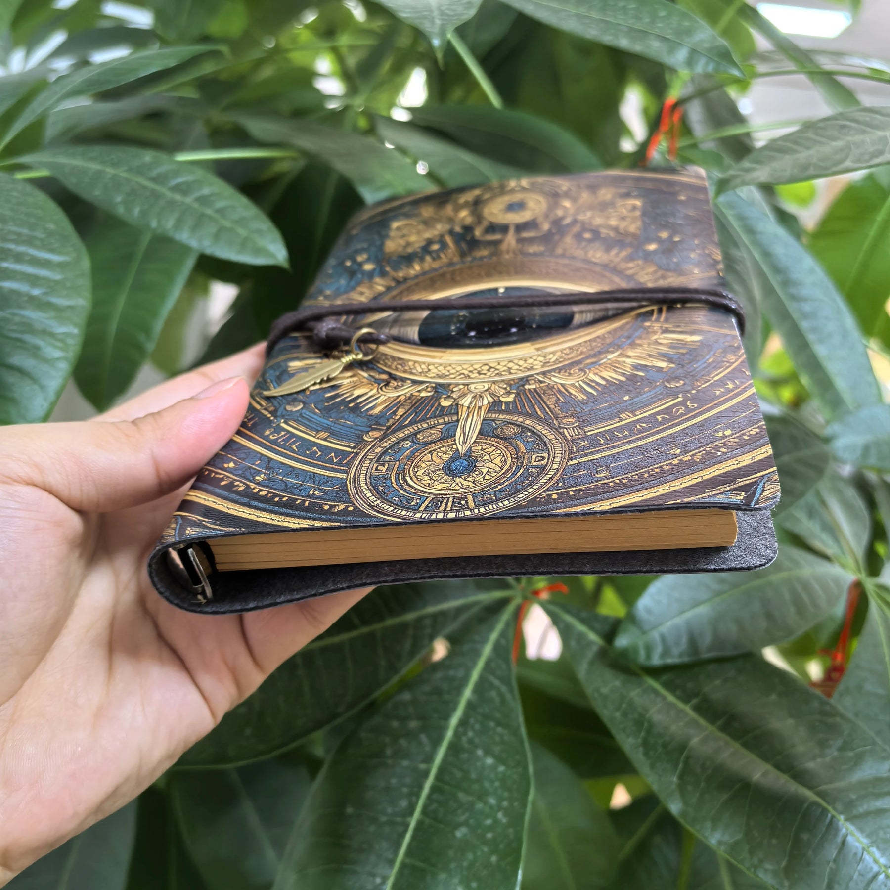 Angled view of the gothic eye journal showing its brown page edges, cover thickness and wrap cord.