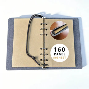 Refillable gothic journal opened to plain brown paper and six binder rings, with a close-up of the ring mechanism and page-count label.