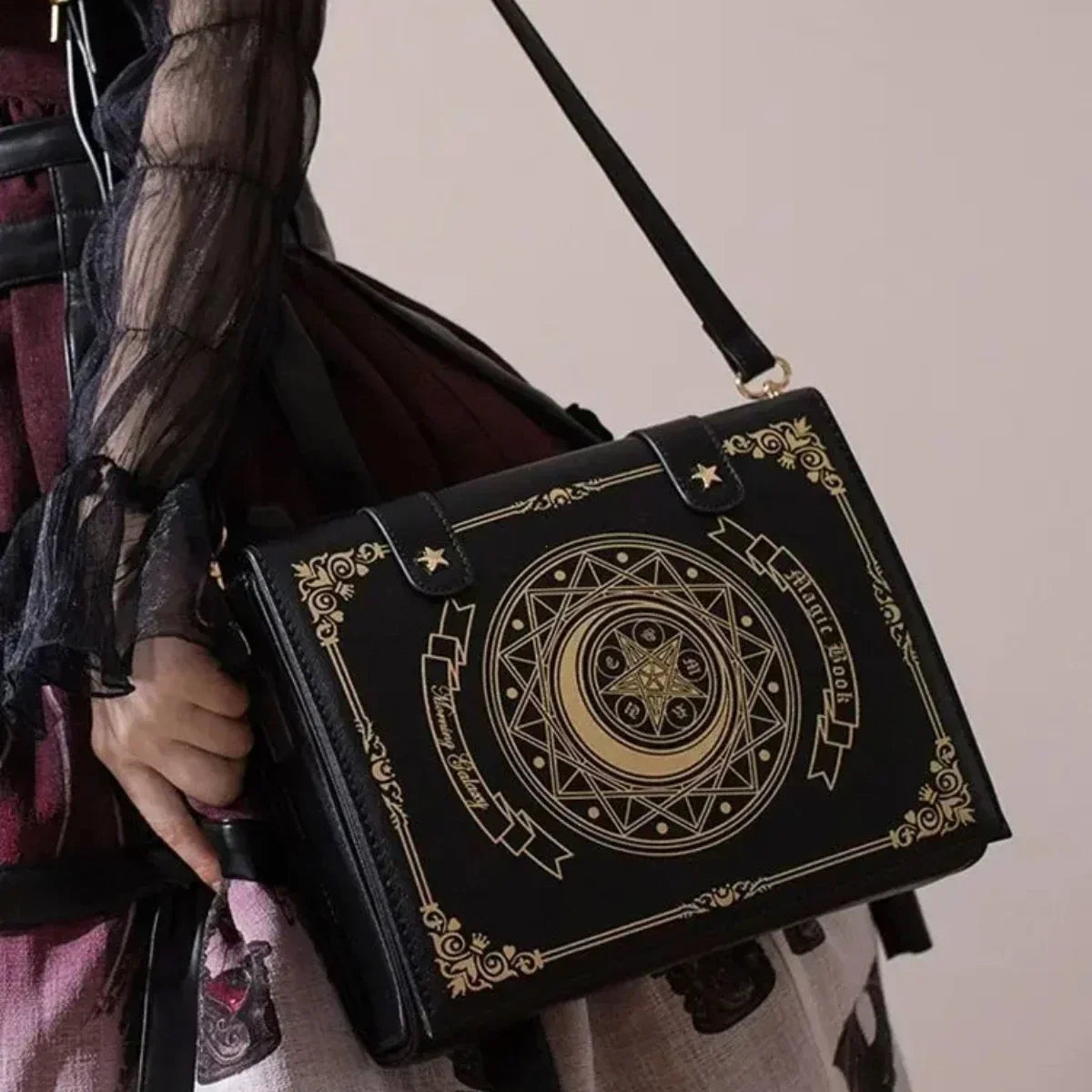 Angled view of black gothic book bag with gold-tone celestial artwork