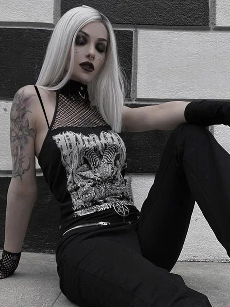 Black Baphomet graphic crop top worn with dark trousers in a seated street-style view, with thin shoulder straps and a connected mesh neckline.