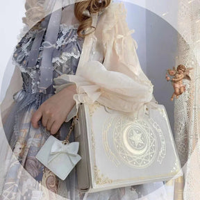 Beige celestial book-inspired shoulder bag worn with a dress