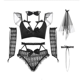 Black bridal lingerie pieces arranged against white: strappy bra with shoulder ruffles, lace briefs, long sleeves, bow choker, veil and a ribbon garter.