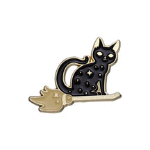 Star-speckled black cat sitting on a gold-tone broom, shown alone on a white background.