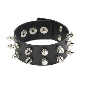 Black cuff bracelet against white with two rows of silver-tone spikes and multiple snap positions visible inside the band.