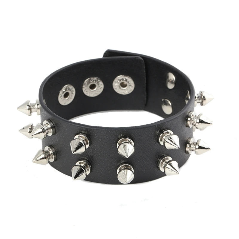 Black cuff bracelet against white with two rows of silver-tone spikes and multiple snap positions visible inside the band.