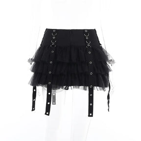 Rear view of the black ruffle skirt on a clear mannequin, showing the back waistband and hanging eyelet straps.