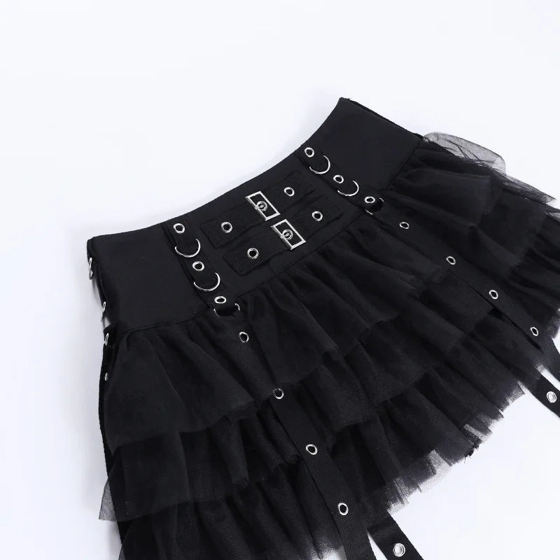Black ruffle skirt laid diagonally on white, displaying the rectangular front hardware, rows of rings and gathered layers.