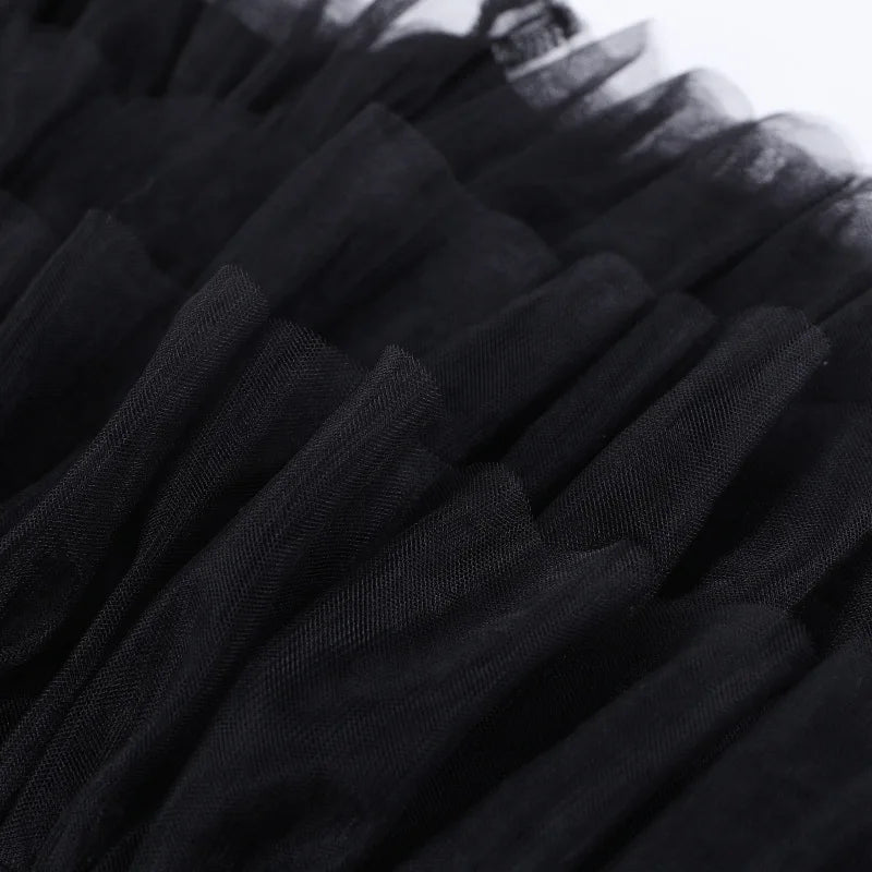 Close view of the black skirt's fine mesh ruffles, showing the gathered texture and overlapping layers.
