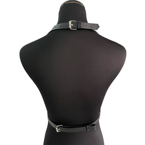 Rear view of the black harness and waist belt on a dress form, showing the rectangular buckles at the neck and waist.