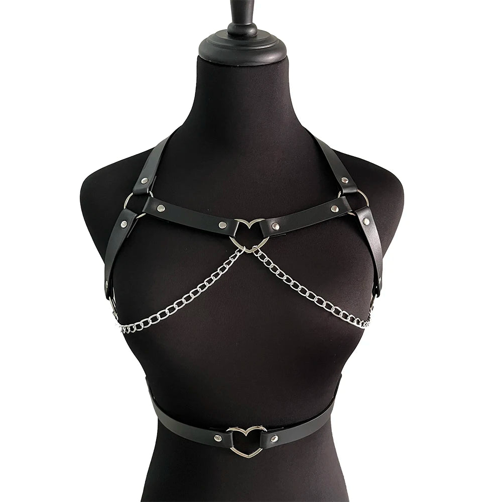 Full front view of the black chest harness and separate waist belt on a black mannequin, with both silver-tone heart rings and chain loops visible.