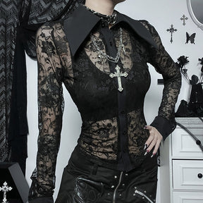 Black floral lace blouse photographed from the front with a separate bralette and cross necklace, showing the contrast between sheer lace and solid trim.