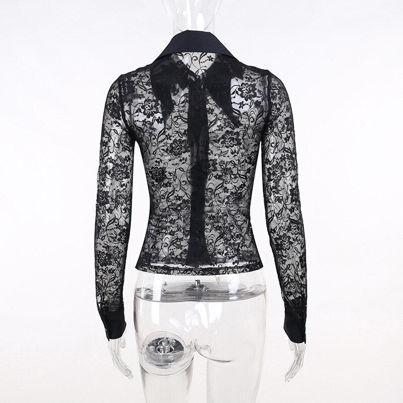 Rear mannequin view of the black lace blouse, showing the transparent floral back, centre seam and long sleeves.