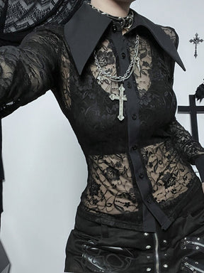 Close styled view of a black floral lace blouse, with sheer waist panels, a solid button placket and sharply pointed collar.