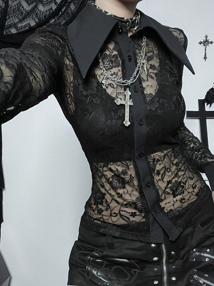 Close styled view of a black floral lace blouse, with sheer waist panels, a solid button placket and sharply pointed collar.