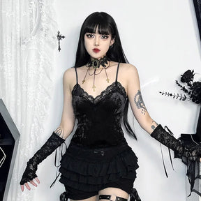 Black version of the lace-trim camisole worn with a ruffled skirt, long lace arm warmers and a cross-chain choker against white lace curtains.