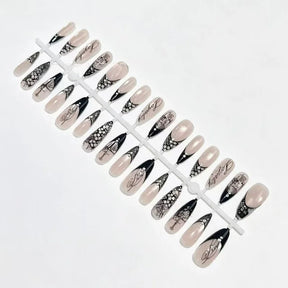 Black lace French nail tips arranged on a display sprue against white, showing the full selection of nude, patterned and dark-tipped designs.
