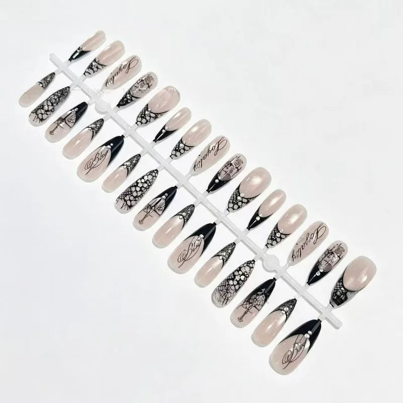 Black lace French nail tips arranged on a display sprue against white, showing the full selection of nude, patterned and dark-tipped designs.