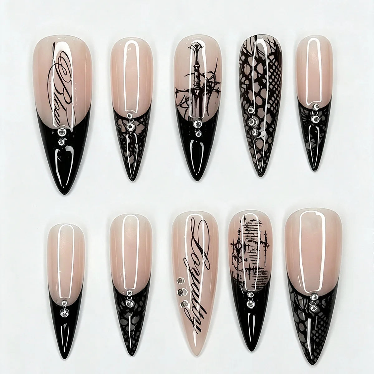 Ten black-and-nude stiletto nail designs displayed on white, showing pointed French tips, lace panels and fine decorative script.