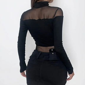 Back view of the black bodysuit worn with trousers, showing the high neckline, transparent shoulder panel and long opaque sleeves.