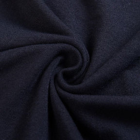 Close-up of the black bodycon dress fabric gathered into a swirl, showing its fine knit surface.