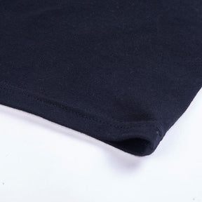 Close-up of the black mini dress hem, showing the folded edge and parallel stitching.