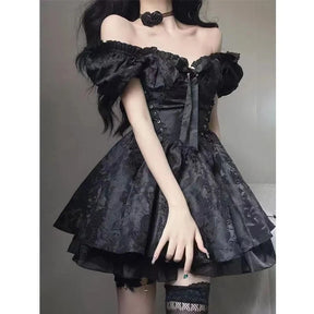 Black gothic mini dress worn with gathered puff sleeves and a large bow at the neckline. The fitted lace-up bodice opens into a floral jacquard skirt with a ruffled layer beneath.
