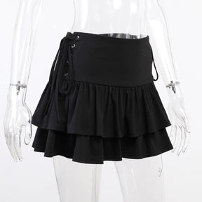 Angled mannequin view of the black tiered skirt, with one side's eyelet lacing visible against white.