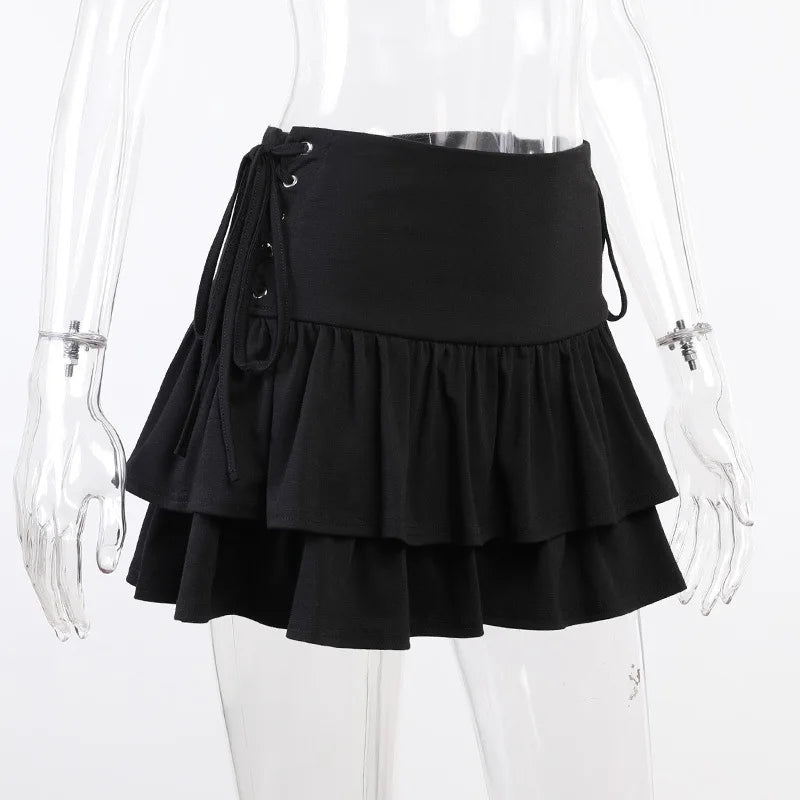 Angled mannequin view of the black tiered skirt, with one side's eyelet lacing visible against white.