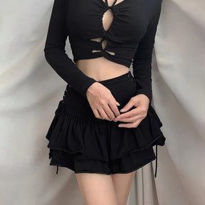 Black side lace-up skirt worn with a black cutout top, with the model's hands resting above the gathered ruffles.