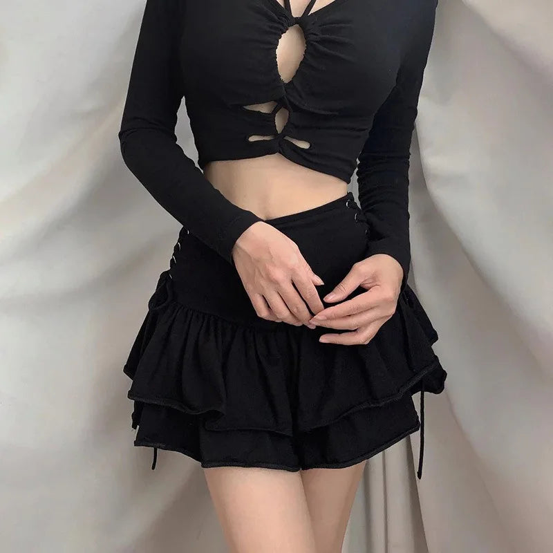 Black side lace-up skirt worn with a black cutout top, with the model's hands resting above the gathered ruffles.