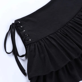Close-up of the black skirt's side lacing, with silver-tone eyelets, black ties and gathered fabric beneath the waistband.