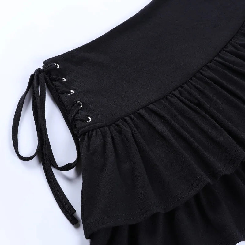 Close-up of the black skirt's side lacing, with silver-tone eyelets, black ties and gathered fabric beneath the waistband.