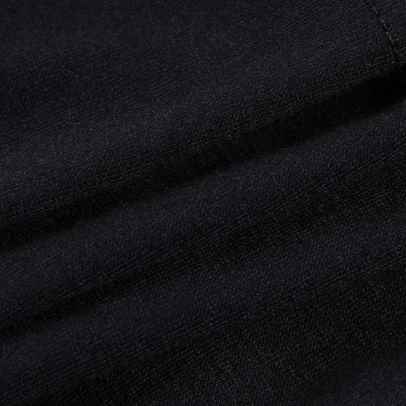 Close view of the black ruffle skirt fabric folded to show its smooth dark surface and fine texture.