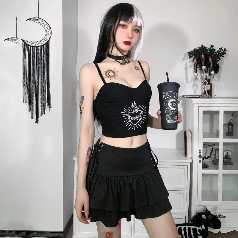 Square mirror outfit view of the black ruffle mini skirt with a black graphic crop top, framed by a white room background.