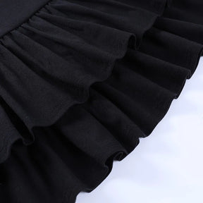 Close view of the black skirt's overlapping gathered ruffles, showing the edges of both tiers.