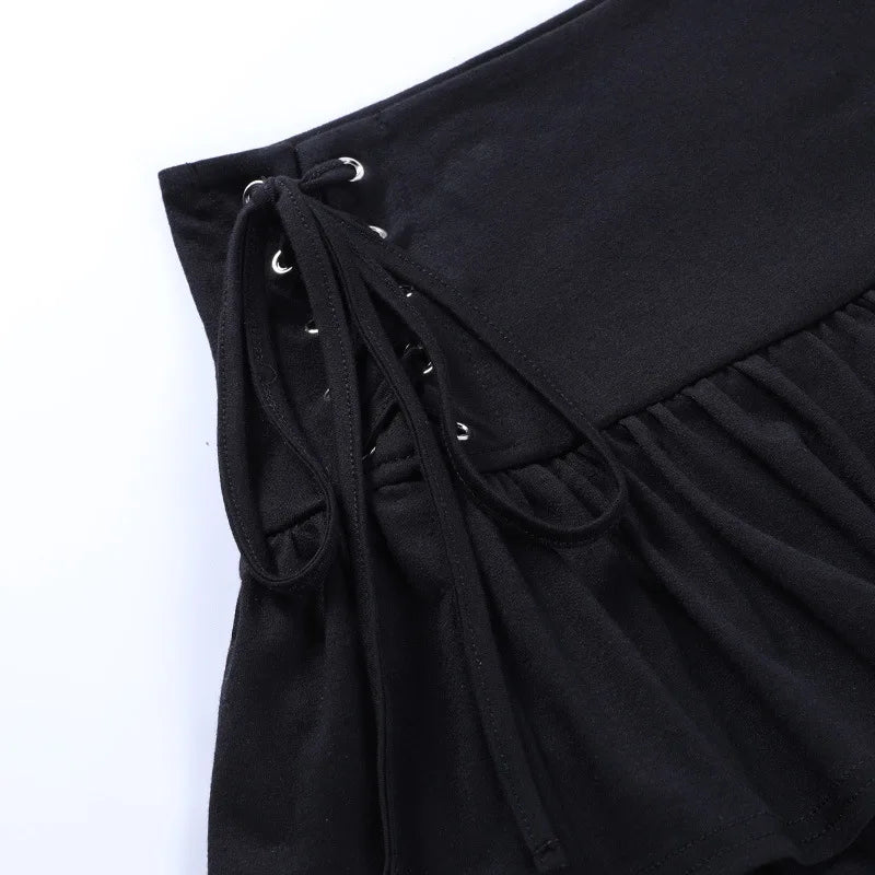 Detail of the black skirt's tied side laces and silver-tone eyelets at the edge of the waistband.