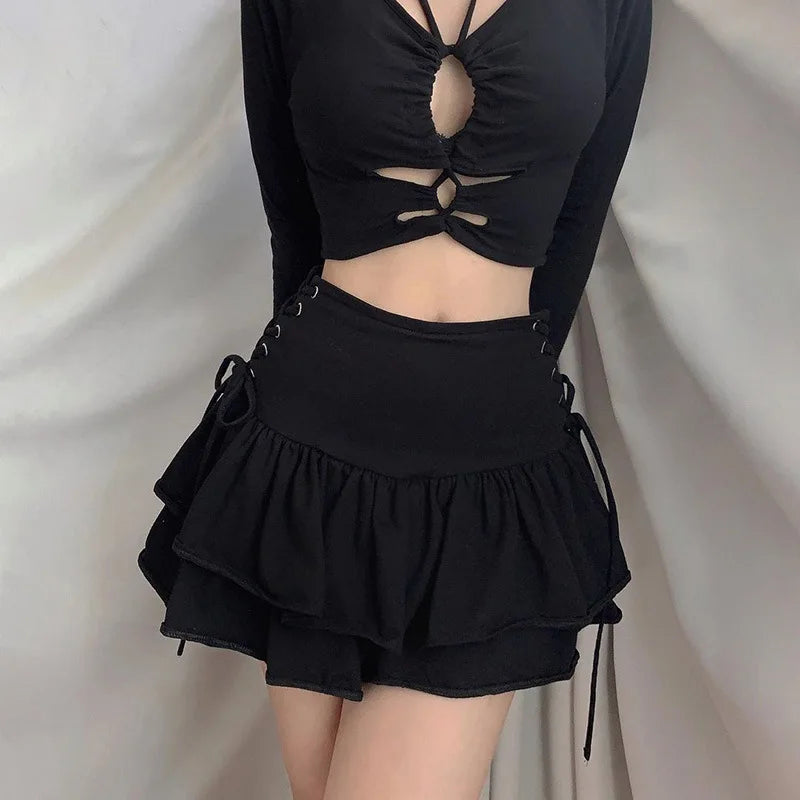 Square front outfit view showing the black skirt's broad waistband and two gathered ruffle tiers below a black cutout top.