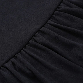 Close-up of the seam where the black skirt's smooth waistband meets its gathered upper ruffle.