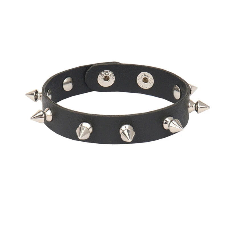 Narrow black cuff bracelet against white with a single row of silver-tone spikes and adjustable snap fastenings.