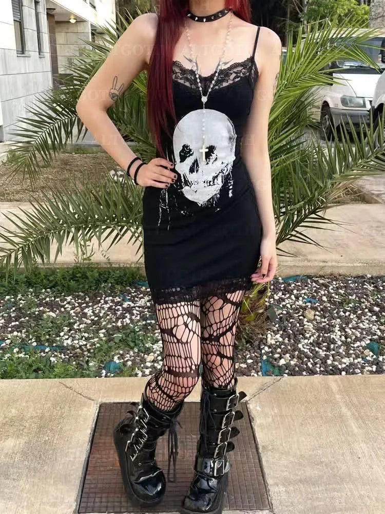 Clean full-length outdoor photograph of the black skull lace dress styled with patterned tights and chunky boots in a garden setting.