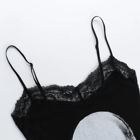 Black dress laid flat to show the floral lace neckline, narrow shoulder straps and the top of the pale skull graphic.