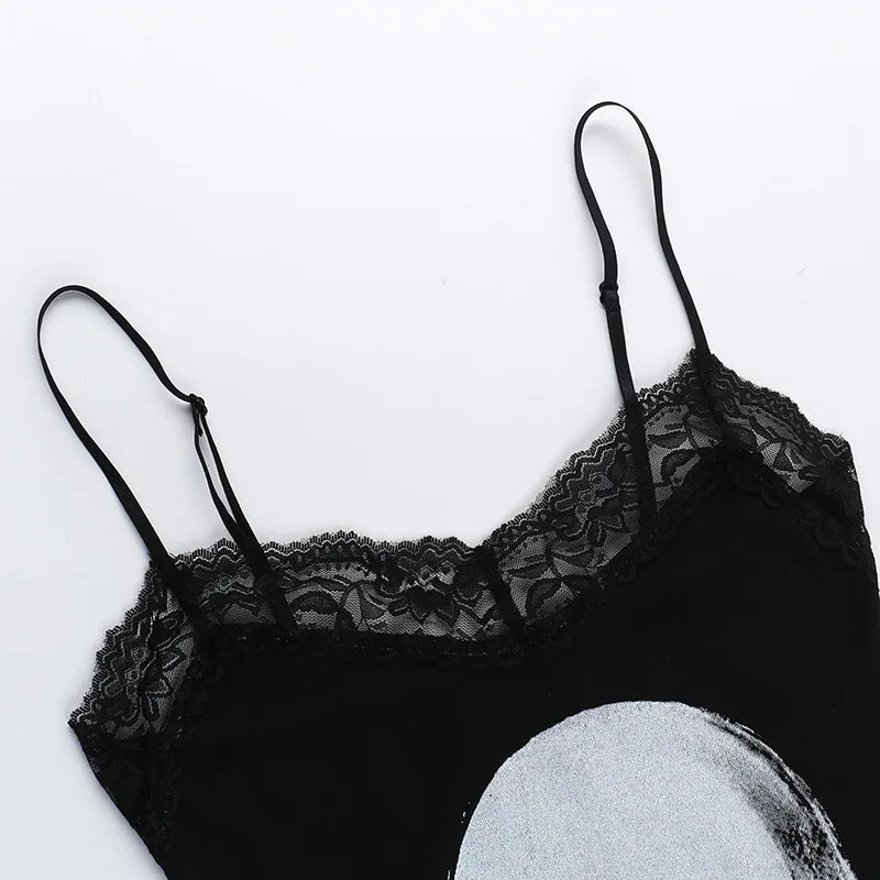 Black dress laid flat to show the floral lace neckline, narrow shoulder straps and the top of the pale skull graphic.