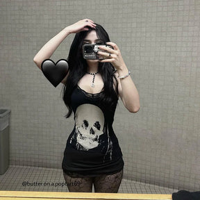Model wearing the black skull mini dress with one arm raised in a mirror photograph, showing the lace neckline and slender straps.
