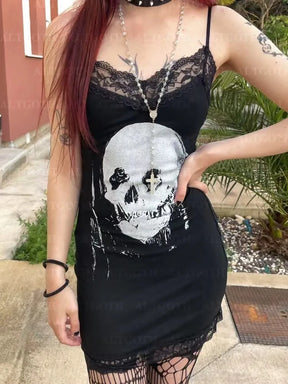 Close outdoor outfit view of the black mini dress, with its large pale skull print centered below the floral lace neckline.
