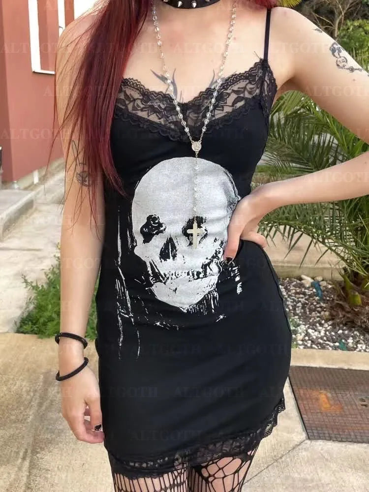 Close outdoor outfit view of the black mini dress, with its large pale skull print centered below the floral lace neckline.