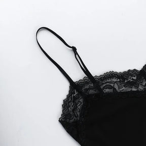 Close-up of a slender shoulder strap and floral lace neckline on the black skull mini dress.