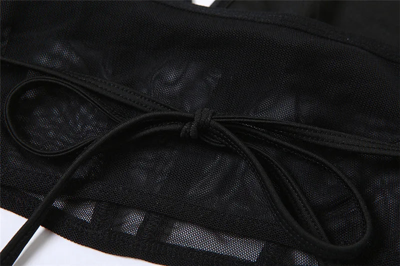 Detail of the black top's back ties resting over its sheer mesh band.