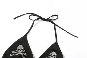 Upper flat view of the black skull halter top, with long neck ties arranged above the triangular cups.