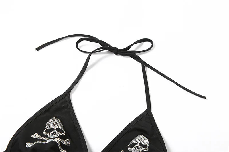 Upper flat view of the black skull halter top, with long neck ties arranged above the triangular cups.